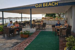 a group of people sitting at tables at an outdoor restaurant at Oji Beach Hotel in Hacılar +16 photos