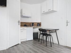 a kitchen with a table and chairs in a room at Le Petit Jules in Dijon