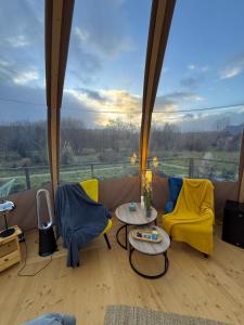 a room with two chairs and tables and a large window at Wigwam Bel'Etoile in Bellencombre