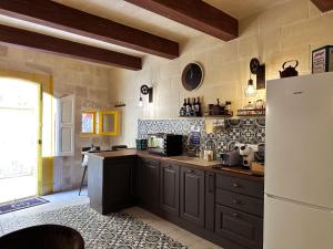 a kitchen with gray cabinets and a white refrigerator at Mandaraggio Stays in Victoria