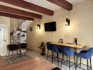 a kitchen with a bar with blue bar stools at Mandaraggio Stays in Victoria