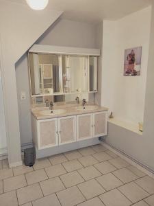 a bathroom with two sinks and two mirrors at L’AMIRAL in Châtillon-Coligny