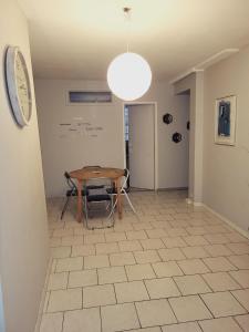 a dining room with a table and a clock on the wall at L’AMIRAL in Châtillon-Coligny