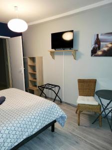 a bedroom with a bed and a tv and chairs at L’AMIRAL in Châtillon-Coligny