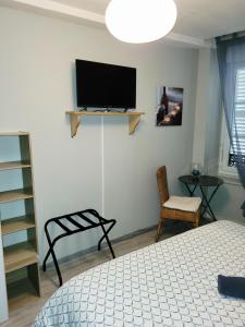 a bedroom with a bed and a tv on the wall at L’AMIRAL in Châtillon-Coligny +5 photos