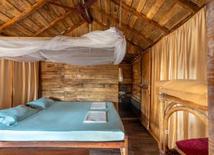 a bedroom with a bed in a wooden cabin at Blue Corner Beach Huts & Restaurant in Benaulim