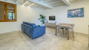 a living room with a blue couch and a table at Cascina Pizzo in San Martino Olearo