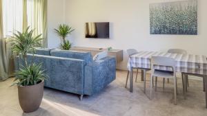 a living room with a blue couch and a table at Cascina Pizzo in San Martino Olearo