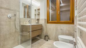 a bathroom with a toilet and a glass shower at Cascina Pizzo in San Martino Olearo +8 photos