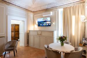 a dining room with a table and chairs and a tv at ViCity Orvieto, la Casa degli Affreschi e la Casa del Giardino Segreto in Orvieto