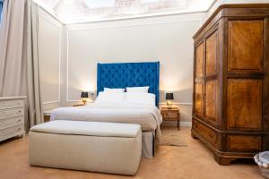 a bedroom with a large bed with a blue headboard at ViCity Orvieto, la Casa degli Affreschi e la Casa del Giardino Segreto in Orvieto