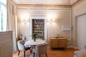 a dining room with a table and chairs and a book shelf at ViCity Orvieto, la Casa degli Affreschi e la Casa del Giardino Segreto in Orvieto
