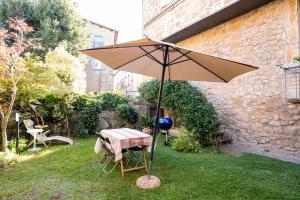 a table with an umbrella in the grass at ViCity Orvieto, la Casa degli Affreschi e la Casa del Giardino Segreto in Orvieto