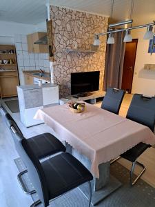 a kitchen with a table and chairs and a fireplace at Wasgauer Felsen und Seenland in Ludwigswinkel