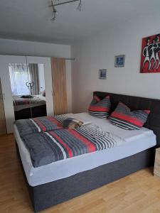 a bedroom with a large bed with red and black pillows at Wasgauer Felsen und Seenland in Ludwigswinkel