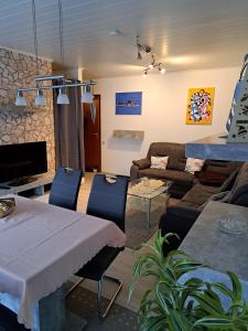 a living room with a table and a couch at Wasgauer Felsen und Seenland in Ludwigswinkel