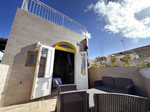 a patio with a table and chairs and an open door at Mandaraggio Stays in Victoria