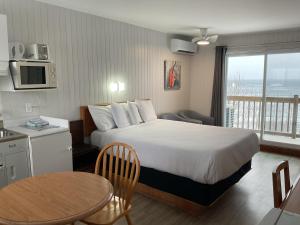 a hotel room with a bed and a table at Motel Carleton Sur Mer in Carleton-sur-Mer