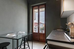 a kitchen with a table and a door with a window at Mistral Holidays - Minisuite Centralissima in Marina di Carrara