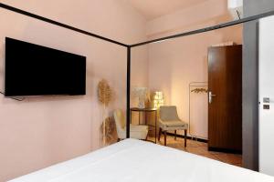a bedroom with a bed and a tv on a wall at Mistral Holidays - Minisuite Centralissima in Marina di Carrara