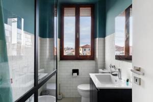 a bathroom with a sink and a toilet and windows at Mistral Holidays - Minisuite Centralissima in Marina di Carrara +5 photos