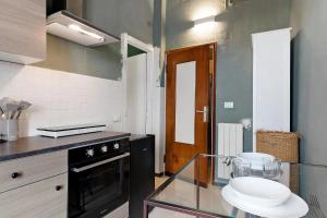 a kitchen with a glass counter top and a stove at Mistral Holidays - Minisuite Centralissima in Marina di Carrara