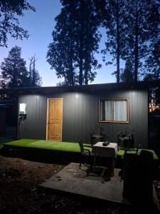 a small house with a green lawn in front of it at My Refugio Wet Wet in Puerto Montt