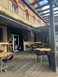 an outdoor patio with tables and chairs and a building at Le Seysses in Seysses