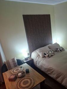 a bedroom with a bed and a table with hats on it at My Refugio Wet Wet in Puerto Montt