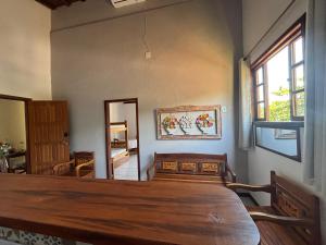 a dining room with a wooden table and a window at FLATS e SUÍTES NATIVA in Paraty