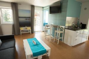 a living room with a couch and a table and a kitchen at Seeland Lodge in Hilpoltstein