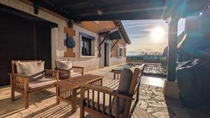 three chairs and a wooden table on a patio at Rioja en calma in Villalobar de Rioja