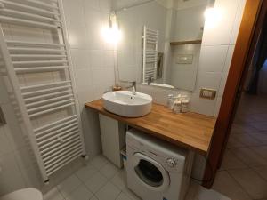 a bathroom with a sink and a washing machine at La casetta di Nonno Carlo a due passi dall'ospedale in Torrette