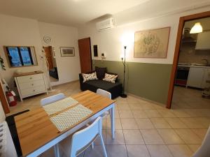 a living room with a table and a couch at La casetta di Nonno Carlo a due passi dall'ospedale in Torrette