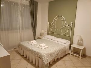 a bedroom with a bed with two towels on it at La casetta di Nonno Carlo a due passi dall'ospedale in Torrette