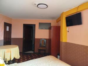 a hotel room with a bed and a flat screen tv at Hotel Condeza in La Paz