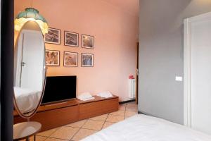 a bedroom with a mirror and a television at Mistral Holidays - Minisuite con Terrazzino in Marina di Carrara