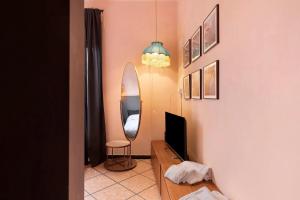 a living room with a television and a mirror at Mistral Holidays - Minisuite con Terrazzino in Marina di Carrara