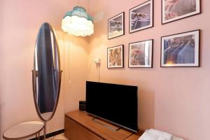 a living room with a flat screen tv and a mirror at Mistral Holidays - Minisuite con Terrazzino in Marina di Carrara +3 photos