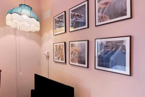 a wall with pictures on a wall with a tv at Mistral Holidays - Minisuite con Terrazzino in Marina di Carrara