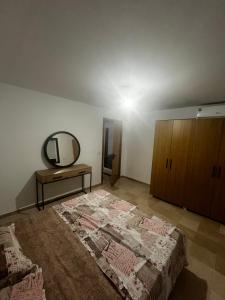 a bedroom with a large bed and a mirror at Sweet homme in El Aouina Station