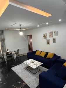 a living room with a blue couch and a table at Sweet homme in El Aouina Station