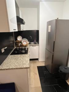 a small kitchen with a stainless steel refrigerator at Sweet homme in El Aouina Station