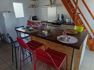 a kitchen with a table with four red chairs at maison Le Wetz in Sainte-Marie-Kerque