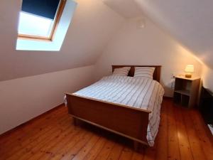 a bedroom with a bed in a attic with a window at maison Le Wetz in Sainte-Marie-Kerque