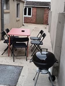 a grill and a table and chairs in a courtyard at maison Le Wetz in Sainte-Marie-Kerque +4 photos