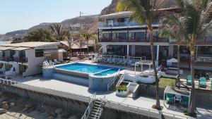 a house with a swimming pool next to a building at Hotel Punta del Mar in Máncora Chico