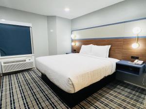 a hotel room with a large bed and a flat screen tv at AmericInn by Wyndham Rawlins in Rawlins