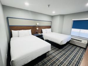 a hotel room with two beds and a window at AmericInn by Wyndham Rawlins in Rawlins