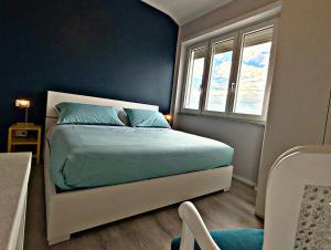 a bedroom with a bed with blue walls and a window at Garba Stop in Rome
